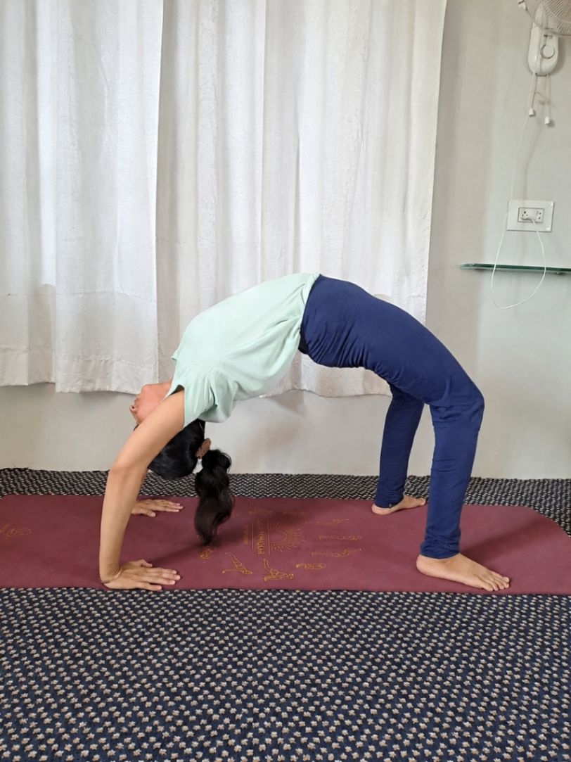 Rabab Bazar, yoga instructor from India teaching a live online backbend class covering the cobra and upward dog poses used in the sun salutation sequence