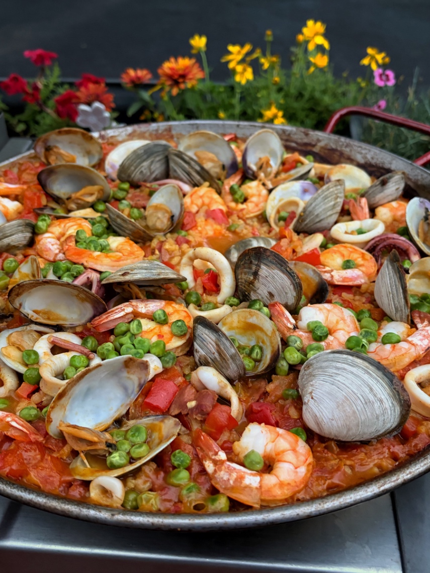 Authentic Spanish paella mixta with chicken, chorizo, shrimp and mussels in a wide paella pan — from P2Bridge's live online paella class