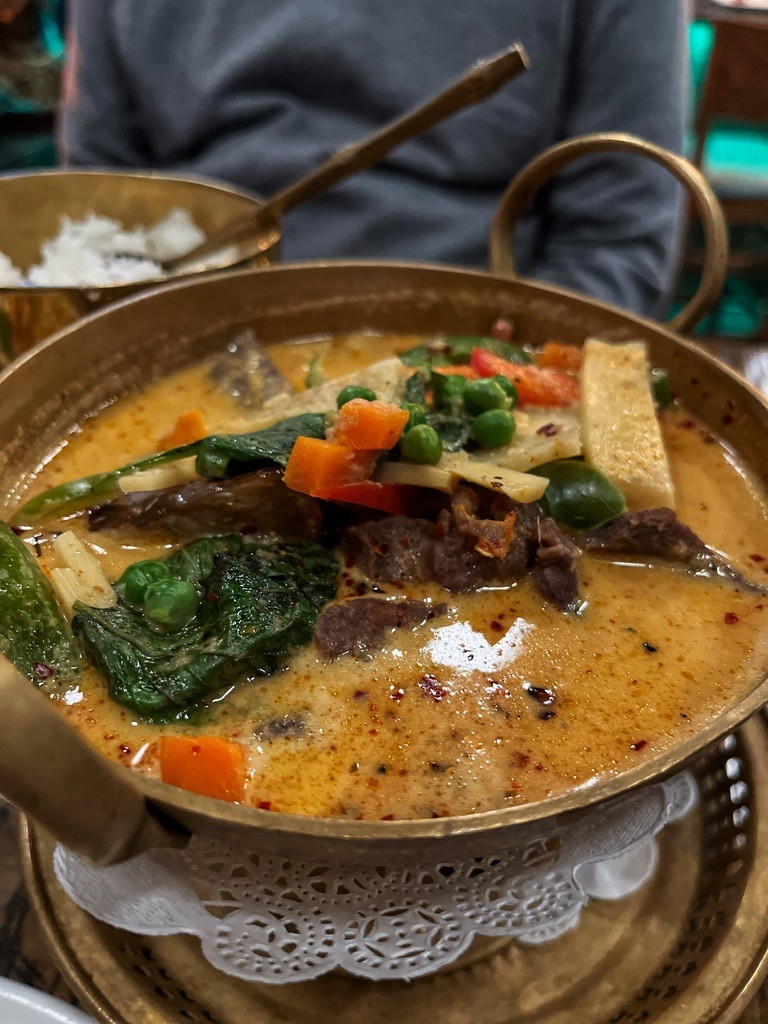 Thai tom yum soup with prawns, lemongrass and galangal alongside panang curry beef, from a live online Thai cooking class